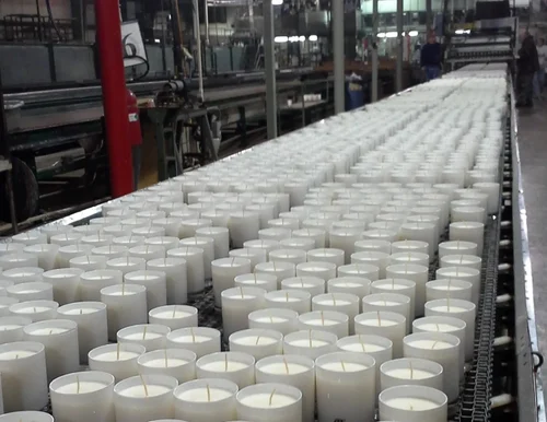 Wickbond candle production line in Kanpur with hundreds of poured candles moving on the conveyor
